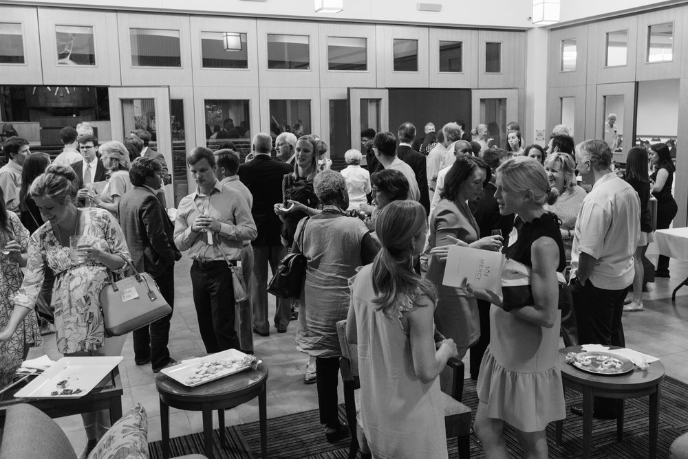 People talking around refreshment tables in a bright church hall.
